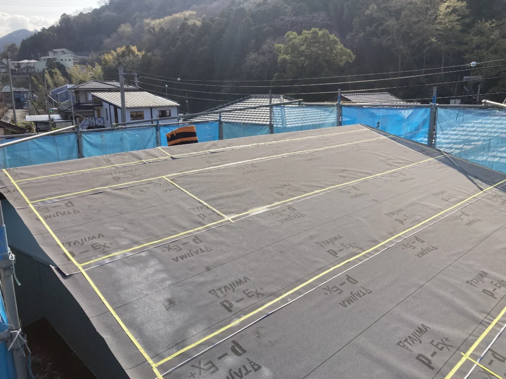 防水シートは必ず屋根の低い方（軒先）から高い方（棟）に向かって、横方向に転がしながら敷いていきます。