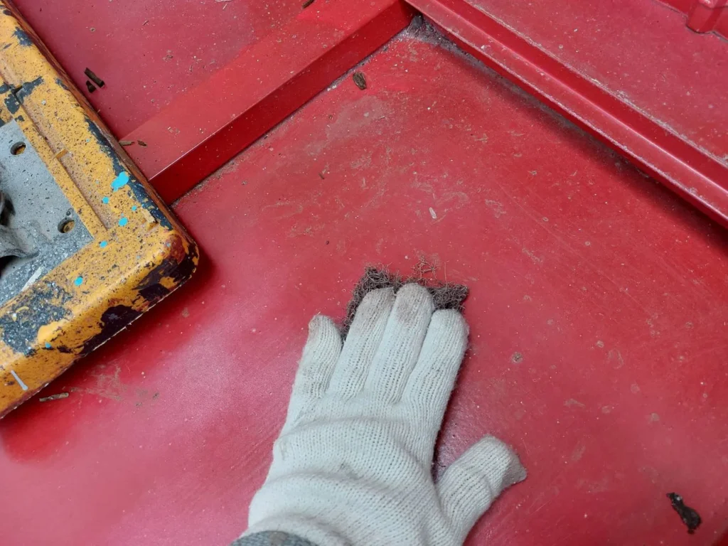 塗装前にケレンをして金属屋根のサビをヤスリで落とし、表面に凹凸を付けることで塗料を密着させます。